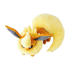 Plush toy of a yellow creature with large ears and a long tail on a white background